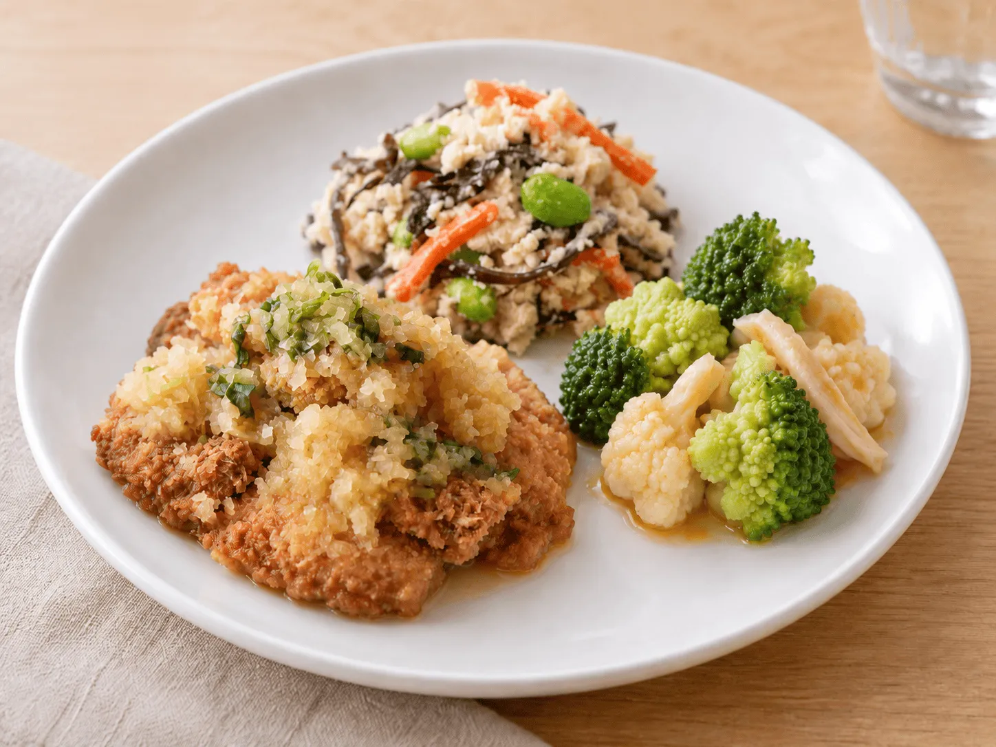 チキンカツの和風おろし、ごま香る白和え、花野菜とチキンのコブサラダを盛り付けた様子